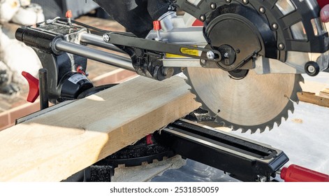 Miter saw tool blade up close for cutting lumber and carpentry. Using a circular saw to cut a wooden board. Blade of a miter saw to cut off the edge of a wooden board. - Powered by Shutterstock