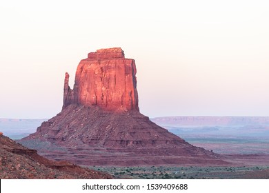 Mittens Butte Mesa Formation With Red Purple Pink Rock Color In Monument Valley Canyons During Sunset Sunlight In Arizona