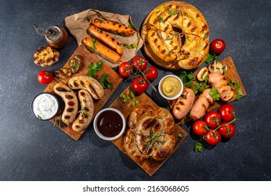 Mix Bar-b-q Sausages - Bavarian, Round, Gumberland, Bratwurst With Ketchup, Mustard Barbeque Sauce. Various Bbq Grilled Sausages Flat Lay On Black Background. Street Festival Grill Food Menu