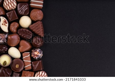 mix chocolate candy on chalkboard, dessert food background.