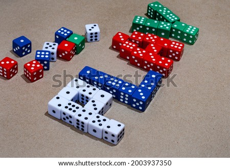 mix of colored playing dice spelling the word play on neutral background