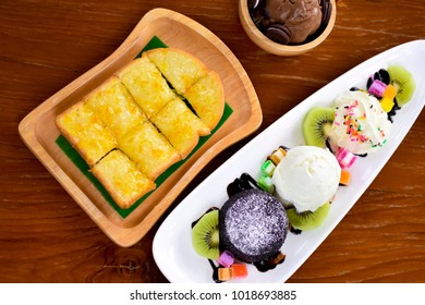 Mix Of Dessert Menu Include Bread Toast With Jam, Vanilla And Chocolate Ice Cream, Kiwi Fruit, Hot Fudge Chocolate Cake. Serve On Wood Table. Wooden Background. All Of These Not Suitable For Diet.