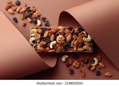 The mix of dried fruits and berries on a brown background. Presented raisins, walnuts, hazelnuts, cashews, pecans, and almonds. Top view. - Shutterstock ID 2148033565