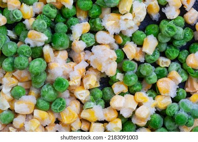 Mix Of Frozen Garden Peas And Corn On Dark Slate Surface