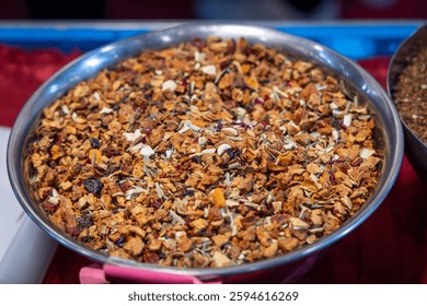 Mix of fruit tea in a metal bowl containing dried fruit pieces and herbs including apple orange peel hibiscus and lemongrass creating an aromatic blend for brewing