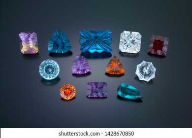 A Mix Group Of Finely Cut, High Grade Fantasy Cut Colored Gemstones On A Dark Background.