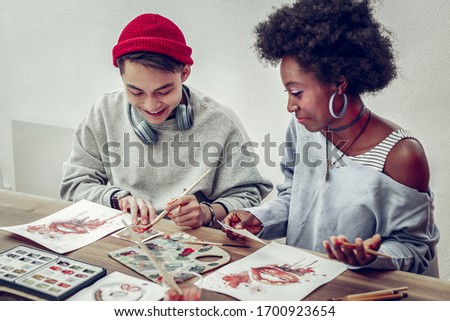 Mix it. Delighted mixed raced people expressing positivity while enjoying art therapy