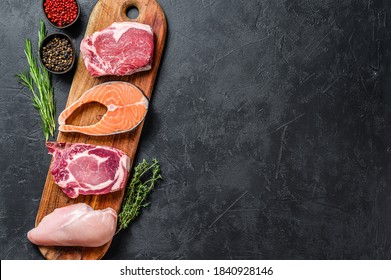 Mix of meat raw steaks salmon, beef, pork and chicken. Black background. Top view. Copy space