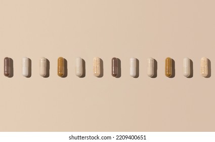 Mix of medical capsules in a line on light beige top view, hard shadows. Preventive medicine and healthcare, dietary supplements and vitamins.  Assorted pharmaceutical medicine capsules - Shutterstock ID 2209400651