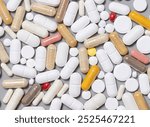 Mix of medical capsules and pills on grey top view. Preventive medicine and healthcare, taking dietary supplements and vitamins.  Assorted pharmaceutical medicine capsules