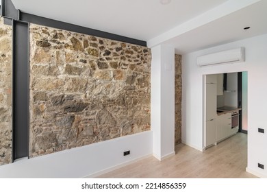 Mix of new and old architecture. Refurbished apartment with restored ancient wall left from old city buildings. Interior of empty renovated room with view to a small kitchen. - Shutterstock ID 2214856359