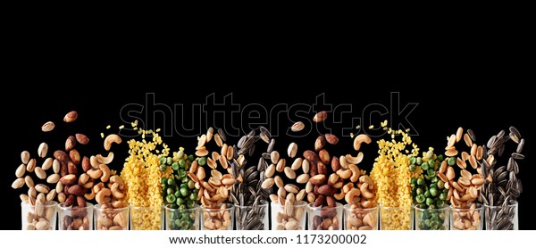 Mix Nuts in the\
glass on black background close up nuts pistachios almond cashew\
nuts peanut sunflower seeds