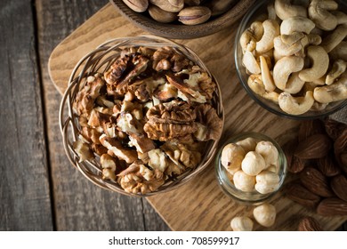 mix of nuts on a wooden table - Shutterstock ID 708599917