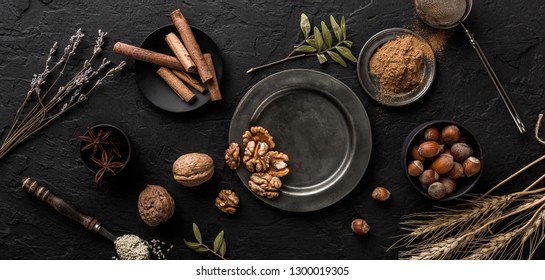 Mix Of Nuts And Spices For Baking Cakes In Bowl And Spoon, Cinnamon, Star Anise, Hazelnuts, Walnuts, Wheat, Lavender On Dark Stone Table. Organic Food, Top View, Space For Text