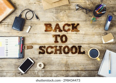 Mix of office supplies with Back to school sign on a wooden desk background. View from above. - Powered by Shutterstock