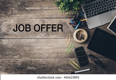 Mix Of Office Supplies And Gadgets On A Wooden Desk With Text - Job Offer