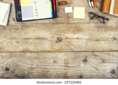Mix of office supplies on a wooden table background. View from above.