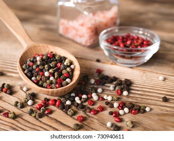 Mix peppercorns in wooden spoon on rustic wooden background. Pink Himalayan salt in glass jar and red pepper in small bowl - Powered by Shutterstock