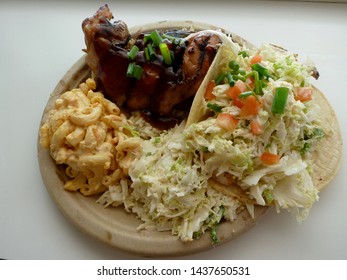 Mix Plate Fish Taco, Kal-Bi, BBQ Chicken With Cole Slaw And Mac Salad On A Paper Plate.