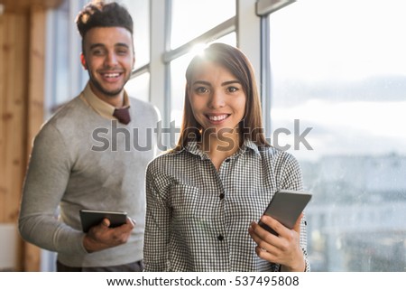 Mix Race Business Man Woman Using Cell Smart Phone Stand in front Panoramic Window Happy Smiling Businesspeople In Coworking Center Office Interior