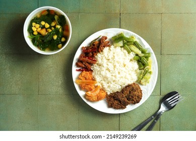 Mix Rice Is A Typical Indonesian Dish, Consisting Of White Rice And Various Side Dishes, Beef, Stir-fried Tofu, Tempeh Oreg, Sweet And Sour Chicken, Stir-fried Broccoli. Served On A Plate. 