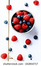 Mix Of Ripe Berries In Bowl On White Wooden Background. Top View.