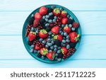 Mix of ripe colorful berries in bowl photography . Blueberry , strawberry , raspberry , blackberry and red currant . Top view on rustic background