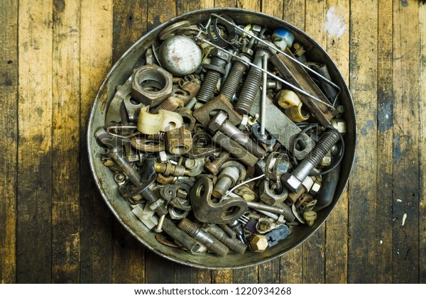 Mix of rusty\
auto scrap including nuts, bolts, springs, washers, cotter pins,\
collected in the old metallic\
can.