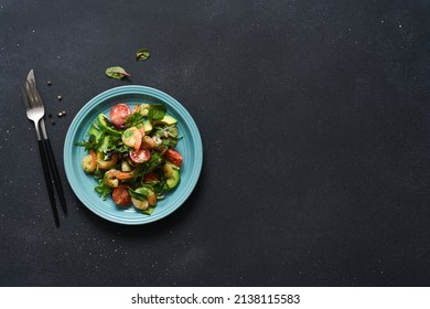 Mix Salad With Tomatoes And Shrimp With Pesto Sauce On A Black Background. View From Above