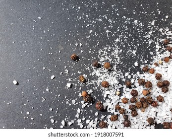 Mix Of Salt And Black Pepper On A Black Background