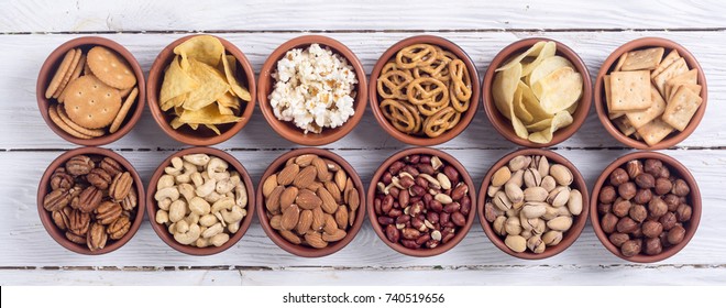 Mix of snacks : pretzels , crackers , chips , nuts and nachos