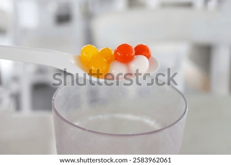 Mix tapioca pearls for bubble tea. Tapioca pearls on white spoon. It's small chewy balls made from tapioca starch, commonly used as a topping in milk tea drinks
