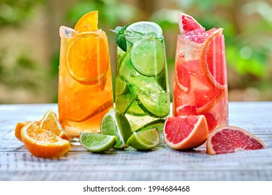 Mix of three ice refreshing drinks with orange, lime and grapefruit Cold refreshing cocktails - a healthy drink for detoxification. Summer refreshing drink. Cold water for detoxification  