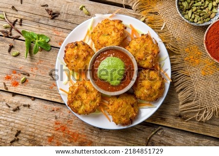 Mix veg pakora with tomato mint sauce on old wooden table top view