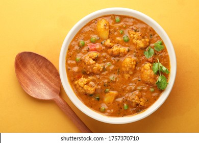 MIX VEGETABLE CURRY- indian recipe, mixed veg containing Carrots, cauliflower, green peas and beans with traditional masala and curry, red hot and spicy served in a ceramic bowl