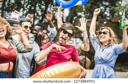 Mixed age diverse people having fun out side cheering with boombox at luxury party - Happy friends group enjoying spring break festival together at private villa - Life style concept on vivid filter