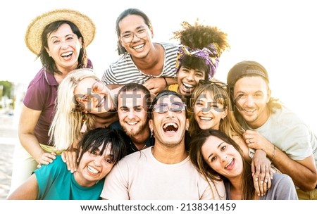 Mixed age range friends taking selfie at beach festival - Happy life style and summer vacation concept on trendy multicultural people having fun day together out side - Bright warm vivid filter