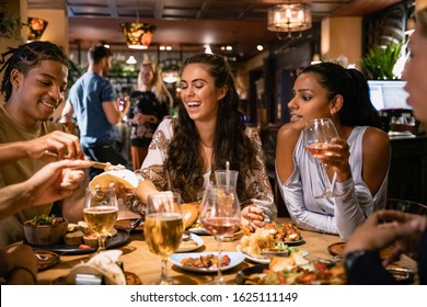 A Mixed Age Range Group Of Friends Having A Meal Together At A Restaurant.