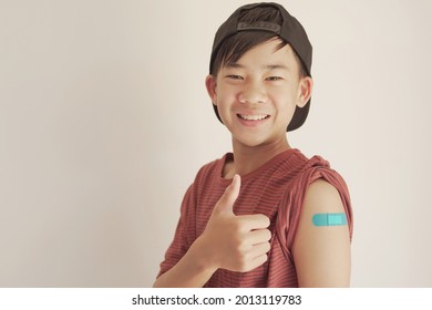 Mixed Asian Teen Boy Giving Thumb Up And Showing His Arm With Blue Bandage After Got Vaccinated Or  Inoculation, Child Immunization, Covid Delta Vaccine Concept