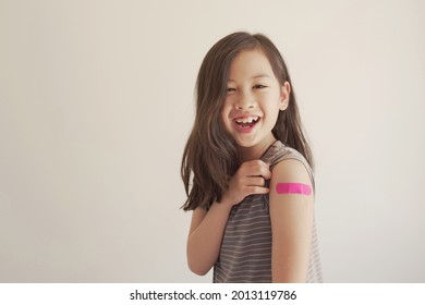 Mixed Asian Young Girl Showing Her Arm With Pink Bandage After Got Vaccinated Or  Inoculation, Child Immunization, Covid Delta Vaccine Concept