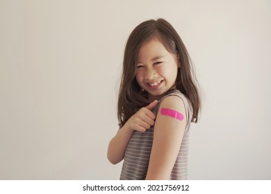 Mixed Asian Young Girl Showing Her Arm With Pink Bandage After Got Vaccinated Or  Inoculation, Child Immunization, Covid Delta Vaccine Concept