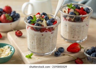 Mixed berries overnight oats with almond flakes in glass jar, healthy breakfast - Shutterstock ID 2195850329