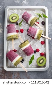 Mixed Berry Kiwi And Yogurt Ice Cream Popsicles On Metal Tray Overhead View