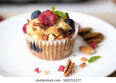 Mixed Berry Low Carb Keto Diet Muffin With Almond And Nut. Set On Cafe Table.