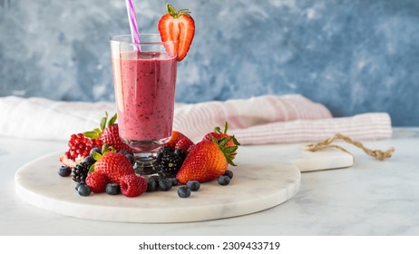 A mixed berry smoothie surrounded by fresh berries, ready for drinking. - Powered by Shutterstock