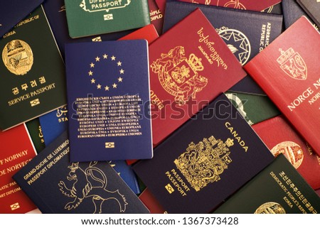 Mixed biometric passports of many countries of the world. In the foreground is a European Union passport.
