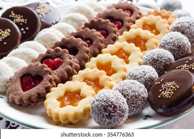 Mixed Christmas Cookies In Line On A White Plate.