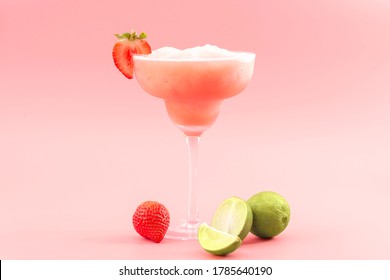 Cócteles mixtos, suavidades para picar fiestas y el concepto de bebidas de verano congeladas con mojito de fresa o daiquiri en gafas de margarita, fresas y limas aisladas en fondo rosa