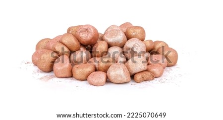 Mixed colored balls of bronzing face powder on table, bronzing pearls isolated on white background.