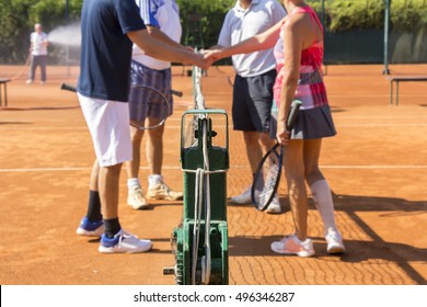 Mixed doubles tennis players shake hands before and after the tennis match